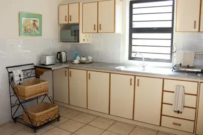 a kitchen with white cabinets and a sink at Die Kelderhuis in Breerivier