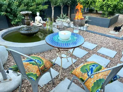 a patio with a table and chairs and a fountain at Spacious Stays Apartment in Paarl