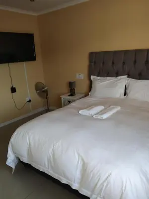 a bedroom with a white bed with two towels on it at On the Wrench in Cape Town