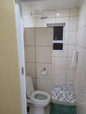 a small bathroom with a toilet and a window at On the Wrench in Cape Town