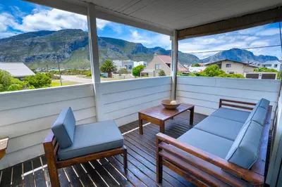 a porch with two chairs and a table at Stony Point Beach House in Clareport