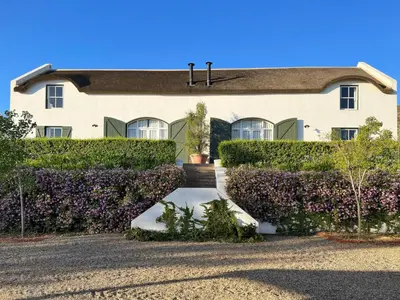 a house with purple bushes in front of it at Penhill Farm West Grange in Nuy
