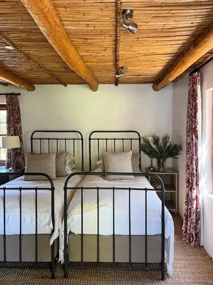 two beds in a bedroom with a wooden ceiling at Penhill Farm Peppertree Cottage in Nuy