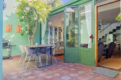 a dining room with a table and a green wall at Casa Lucia in Cape Town