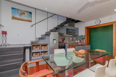 a dining room with a glass table and a staircase at Casa Lucia in Cape Town