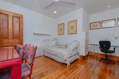 a bedroom with a bed and a desk and a chair at Casa Lucia in Cape Town