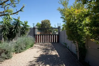 a driveway with a gate in a yard at Sunbird Cottage in Somerset West