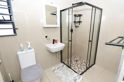 a bathroom with a shower and a toilet and a sink at ELMED GUEST HOUSE in Cape Town