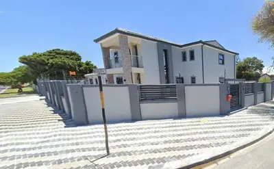 a white house with a fence in front of it at ELMED GUEST HOUSE in Cape Town