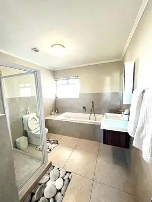 a bathroom with a shower and a tub and a toilet at Ashton Park 221 in Cape Town
