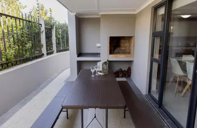 a room with a wooden table on a balcony at MLMK Property 17 in Cape Town