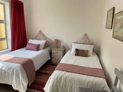 two beds sitting next to each other in a room at Sunset Paradise in Cape Town