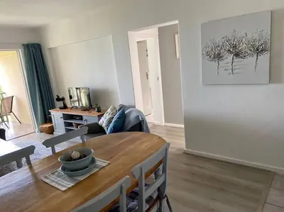 a living room with a table and a couch at Sunset Paradise in Cape Town