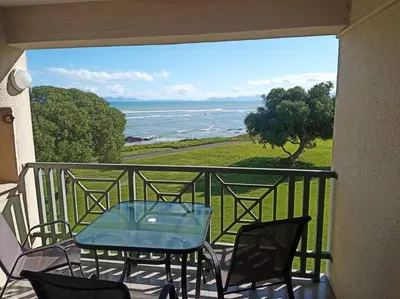 a balcony with a table and chairs and the ocean at Sunset Paradise in Cape Town