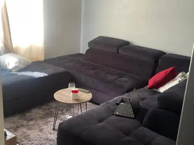 a living room with a couch and a table with a laptop at Eden Heights in Cape Town