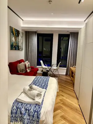 a bedroom with a bed and a living room at Bridgewater one luxury Apartment in Cape Town