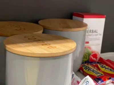 a white cup with a wooden lid on top of it at Bridgewater one luxury Apartment in Cape Town