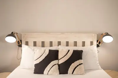 a bed with two lights on top of it at Easy Going Hermanus With An Ocean View in Hermanus