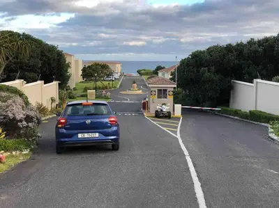 a blue car parked on the side of a road at Easy Going Hermanus With An Ocean View in Hermanus