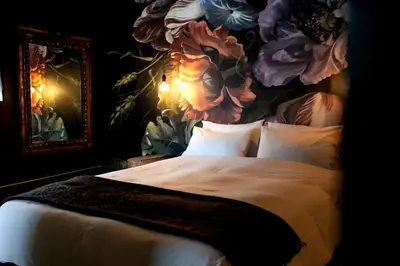 a bedroom with a large bed with a floral wall at Oak on Main in Hermanus