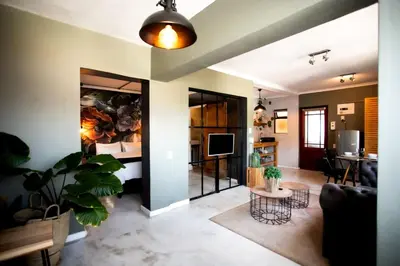 a living room with a couch and a table at Oak on Main in Hermanus