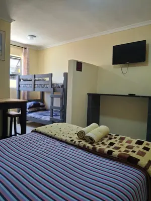 a bedroom with a bed with a tv on the wall at Supa Guesthouse in Parow