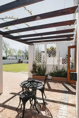a table and chair sitting on a patio at Mitre's Edge Vineyard Studio in Klapmuts