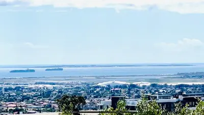 a view of a city with the ocean in the background at Hotel Vibes Cape Town Plattekloof in Cape Town