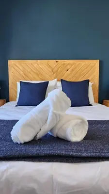 a white blanket laying on top of a bed at Villa Nordica - 2 bedroom self-catering apartment in Cape Town