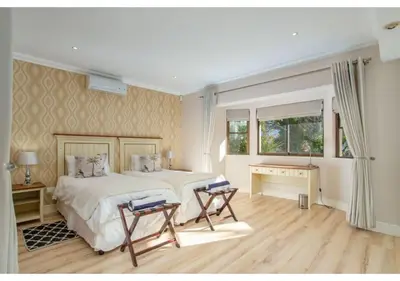 a bedroom with a bed and two chairs in it at Florin’s Crest 3 Bedroom Villa, Franschhoek in Franschhoek