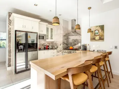 a kitchen with white cabinets and a wooden counter top at Wechmarshof in Stellenbosch