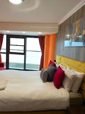 a bedroom with a large white bed with red pillows at Beautiful Ocean View Apartment in Cape Town