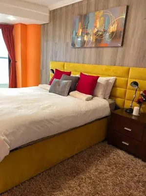 a bedroom with a large bed with red pillows at Beautiful Ocean View Apartment in Cape Town