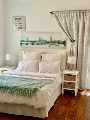 a bedroom with a large bed with a painting on the wall at Beautiful apartment in century city in Cape Town