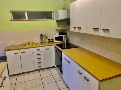 a small kitchen with white cabinets and a microwave at Beautiful apartment in century city in Cape Town