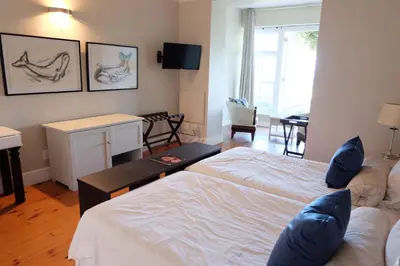 a bedroom with two beds and a living room at 11 WESTCLIFF RENTALS in Hermanus