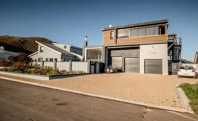 a house with a car parked in front of a driveway at Escape to Pringle in Pringle Bay