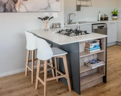a kitchen with a island with two stools and a stove at Escape to Pringle in Pringle Bay