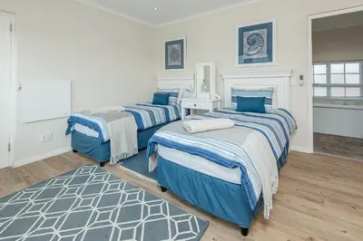 a bedroom with two beds and a rug at Mountain View by Top Destinations Rentals in Hermanus