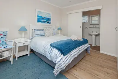 a bedroom with a bed and a sink in it at Mountain View by Top Destinations Rentals in Hermanus