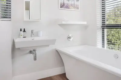 a white bathroom with a sink and a bath tub at Kingklip by Top Destinations Rentals in Hermanus