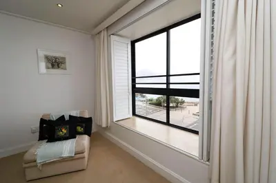 a living room with a large window and a couch at Hermanus Seaview Apartment in Hermanus