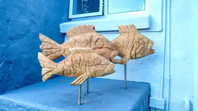a wooden fish sculpture in front of a blue wall at Rox Villa in Rooiels