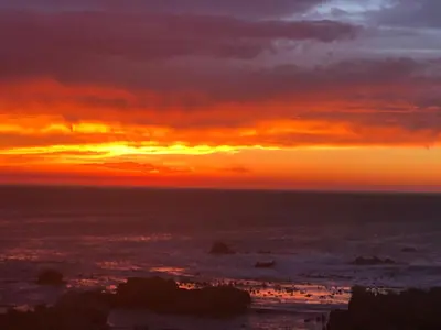 a sunset over the ocean with the sun setting at Rox Villa in Rooiels