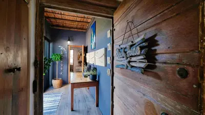 a hallway with blue walls and a wooden door at Rox Villa in Rooiels
