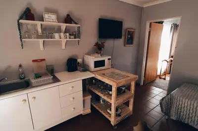 a kitchen with a desk with a microwave on it at Garden cottage in Cape Town