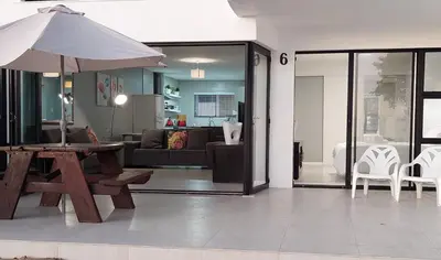a living room with a table and an umbrella at Cap du Mont in Bloubergstrand