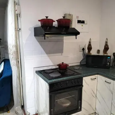 a kitchen with a stove and two pots on a shelf at Naledi homestay in Cape Town