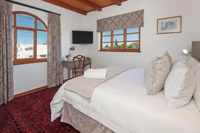 a bedroom with a large bed and a window at Villa Venusta Luxury Guesthouse - Solar Power in Hermanus