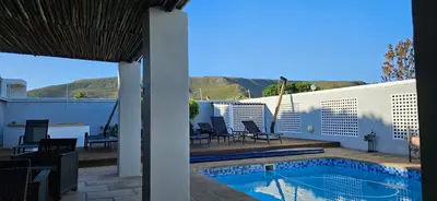 a house with a swimming pool on a patio at Villa Venusta Luxury Guesthouse - Solar Power in Hermanus